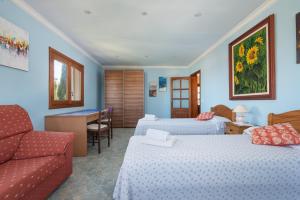 a hotel room with two beds and a couch at Your Island Villa Son Serra in Son Serra de Marina +38 photos