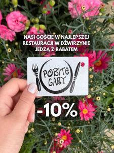 a hand holding a sign with a plate and fork and knife at Biały Domek - STREFA CISZY, CHILDREN FREE in Dźwirzyno +169 photos