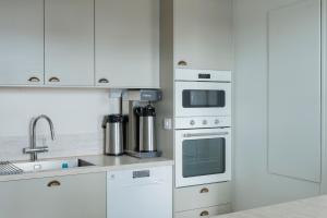 eine Küche mit weißen Schränken und einem Herd mit Backofen in der Unterkunft Villa Evalotta in Fjällbacka