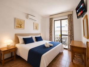 a bedroom with a bed with a tv and a window at Sun Serramar Boutique Hostal in Benalmádena