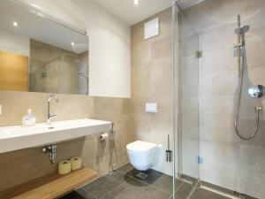 a bathroom with a toilet and a sink and a shower at Luxury Tauern Suite Walchen Kaprun 8 in Walchen +19 photos