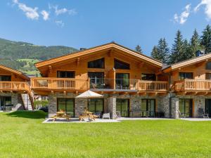 a large log house with a deck and lawn at FIIF Pinzgau in Wald im Pinzgau