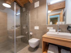 a bathroom with a shower and a toilet and a sink at Chalet Joep in Wald im Pinzgau +53 photos