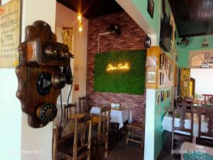 a restaurant with a brick wall and tables and chairs at Pousada e Restaurante Dona Siroba in Morretes