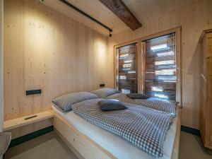 a bed in a wooden room with a window at Raneburg 4 Futterhaus in Matrei in Osttirol