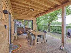 eine Holzterrasse mit einem Tisch und Stühlen darauf in der Unterkunft Veldzicht in Bocholt