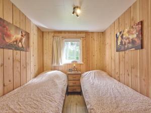 zwei Betten in einem Zimmer mit Holzwänden und einem Fenster in der Unterkunft Veldzicht in Bocholt + 70 Fotos