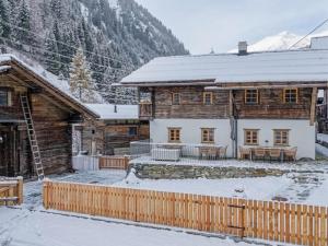 a log cabin in the snow with a wooden fence at Raneburg 4 Futterhaus in Matrei in Osttirol