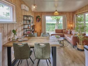 ein Wohnzimmer mit Tisch, Stühlen und Sofa in der Unterkunft Veldzicht in Bocholt