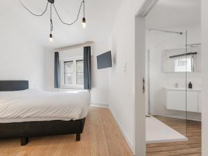 a bedroom with a bed and a glass shower at t Loftje in Veurne