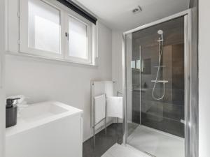 a white bathroom with a shower and a sink at t Loftje in Veurne +31 photos