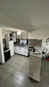 a large kitchen with white appliances and a counter at Lomajobava in Godoy Cruz