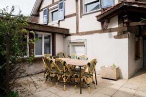 a wooden table and chairs in front of a building at Le Gîte de Jade in Dannemarie