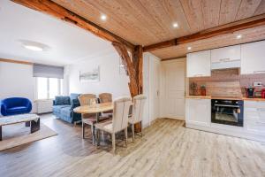 a kitchen and living room with a table and chairs at Le Gîte de Jade in Dannemarie