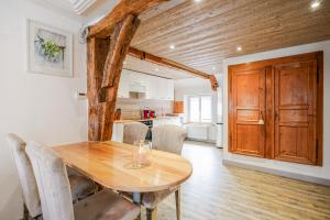 a dining room with a wooden table and a kitchen at Le Gîte de Jade in Dannemarie +51 photos