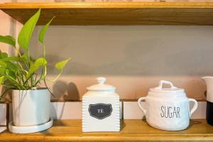 a shelf with two white containers and a plant at Home Chic in Quepos