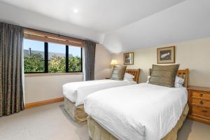 two beds in a room with a window at Lansdown Apartments in Wanaka +21 photos