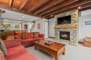 a living room with a couch and a fireplace at Lansdown Apartments in Wanaka