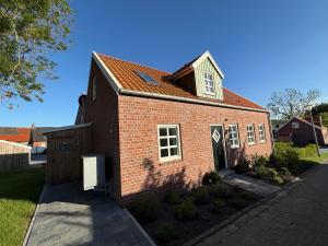 a small red brick house with a door at Ferienhaus Mühle 5 in Krummhörn