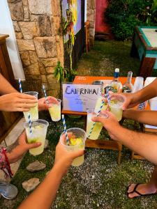 a group of people holding up glasses of drinks at Hostel Mawe in Paraty