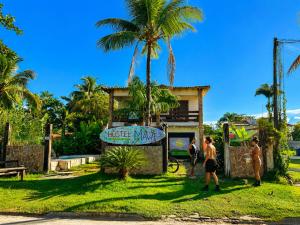 people standing in front of a house with a palm tree at Hostel Mawe in Paraty +16 photos