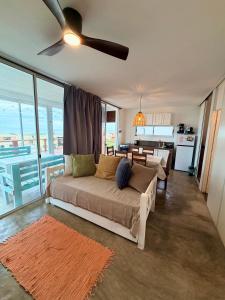 a living room with a couch and a ceiling fan at Acacias PDD in Punta Del Diablo