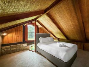 a bedroom with a large bed in a attic at Highwoods Cottage in Pokolbin