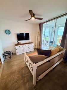 a living room with a couch and a flat screen tv at Acacias PDD in Punta Del Diablo