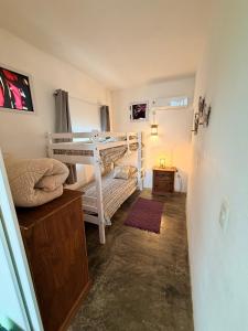 a small room with two bunk beds and a hallway at Acacias PDD in Punta Del Diablo