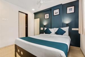 a bedroom with a large bed with blue walls at Hotel O Nirsukh Palace in Navi Mumbai