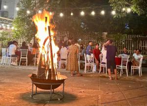 a large fire pit with people standing around it at Roll Huynh in Kon Plong