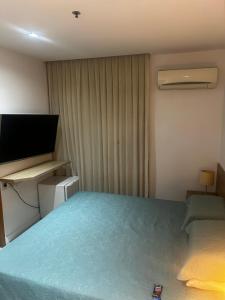 a bedroom with a bed and a flat screen tv at Diamond Flat Aparthotel REDE Mont Blanc in Nova Iguaçu +10 photos