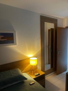 a bedroom with a bed and a lamp on a table at Diamond Flat Aparthotel REDE Mont Blanc in Nova Iguaçu