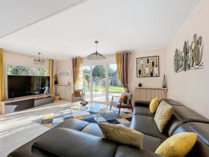 a living room with a couch and a tv at Demeures du Bord de Seine in Samoreau