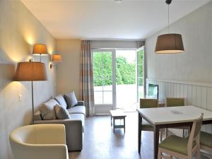 a living room with a couch and a table at Tranquil Apartment with Pool Access in Bagnoles de l'Orne