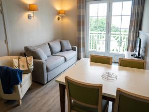 a living room with a couch and a table at Tranquil Apartment with Pool Access in Bagnoles de l'Orne +25 photos