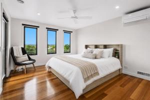 a white bedroom with a large bed and a chair at Nautilus by Ready Set Stay in Rye +11 photos