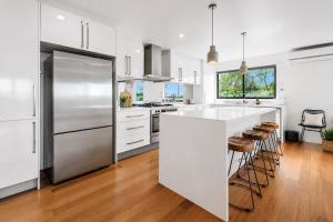 a kitchen with white cabinets and a large refrigerator at Nautilus by Ready Set Stay in Rye