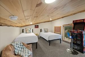 a room with two beds and a video game at Hottub Haven BHBungalows #9 in Custer
