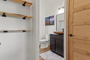 a bathroom with a toilet and a wooden door at Hottub Haven BHBungalows #9 in Custer +60 photos