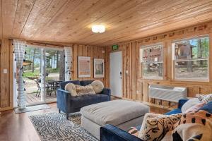 a living room with a blue couch and a chair at The Monet- BHBungalows #1 in Custer