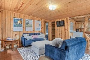 a living room with two blue chairs and a couch at The Monet- BHBungalows #1 in Custer