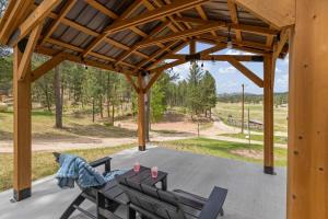 a wooden pavilion with a table and chairs on a patio at The Monet- BHBungalows #1 in Custer