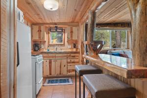 a kitchen with wooden cabinets and a counter with stools at Little Joy BHBungalows #4 in Custer +48 photos
