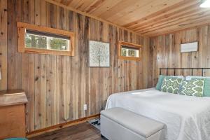 a bedroom with a bed in a wooden wall at Little Joy BHBungalows #4 in Custer