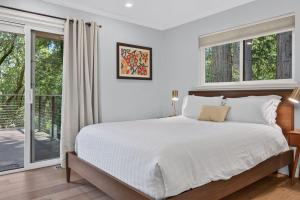 a white bedroom with a large bed and windows at The Enso Sonoma in Glen Ellen