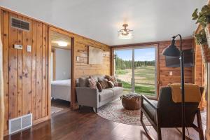 a living room with a couch and a bed and a window at Hobbit Hole BHBungalows #3 in Custer