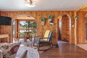 a living room with wooden walls and a table and chairs at Hobbit Hole BHBungalows #3 in Custer +58 photos