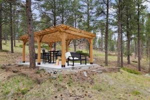 a wooden gazebo with tables and chairs in the woods at Modern Lodge- BHBungalows Main in Custer