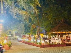 a group of people sitting at a restaurant at night at Hotel Mantra and Adventure in Sauraha
